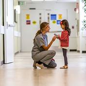 Intermountain Nurse kneeling by child