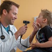physician-looking-into-boys-mouth