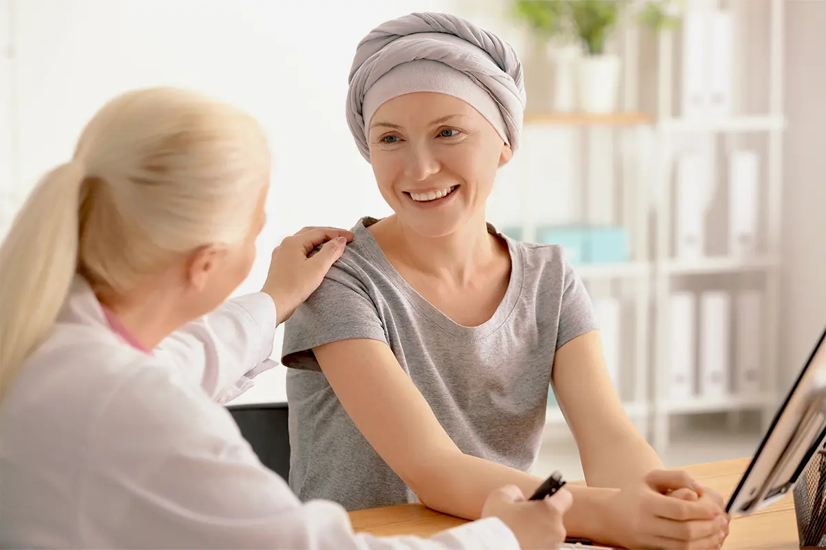 Woman in a gray headband smiling and talking to a woman at home