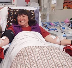 Taki May giving blood sized for Caregiver News