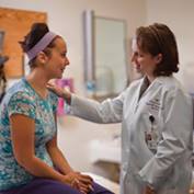 A physician meets with a teenage girl.