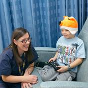 female-nurse-with-boy-playing-video-game