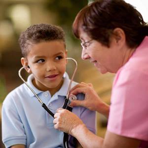 A female physician uses a stethoscope to show a male child his heartbeat