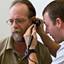 A male physician gives an ear exam to an older male patient