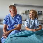physician-talking-to-girl-hospital-bed