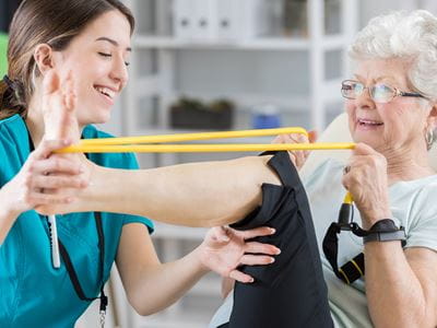 Elderly patient exercises with physical therapist