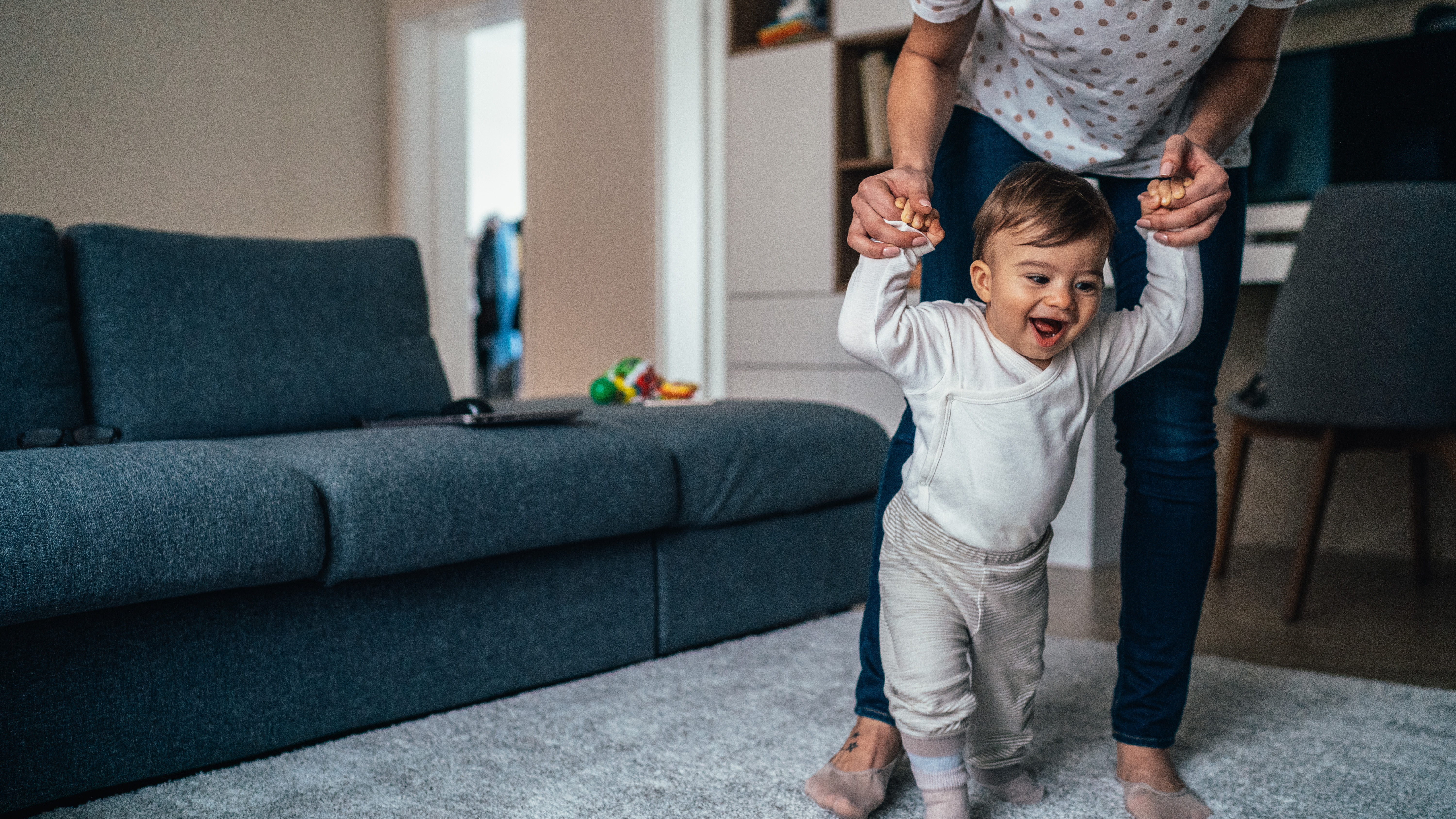 baby walking along furniture