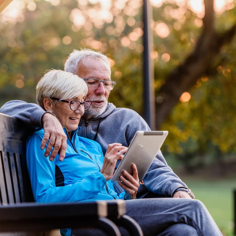 older couple outside looking at a tablet