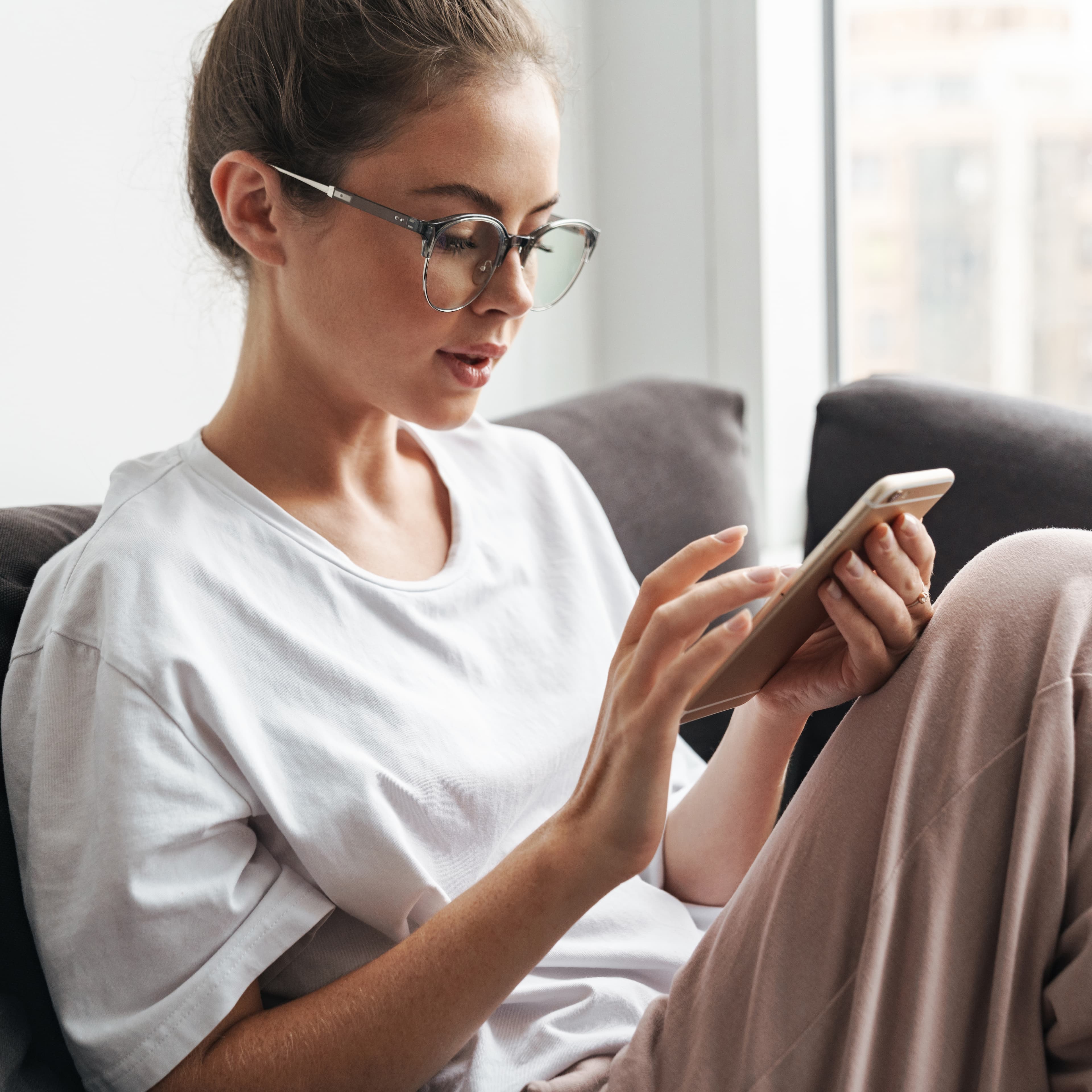 young woman on couch looking at phone