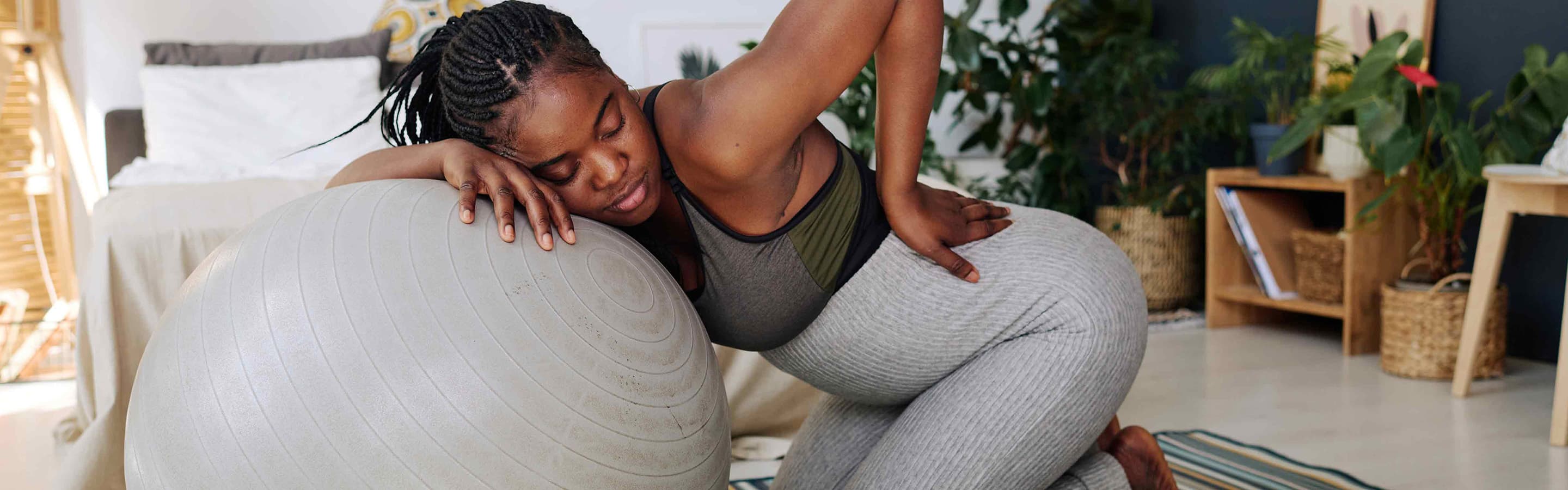 Woman in exercise gear laying on a gray exercise ball