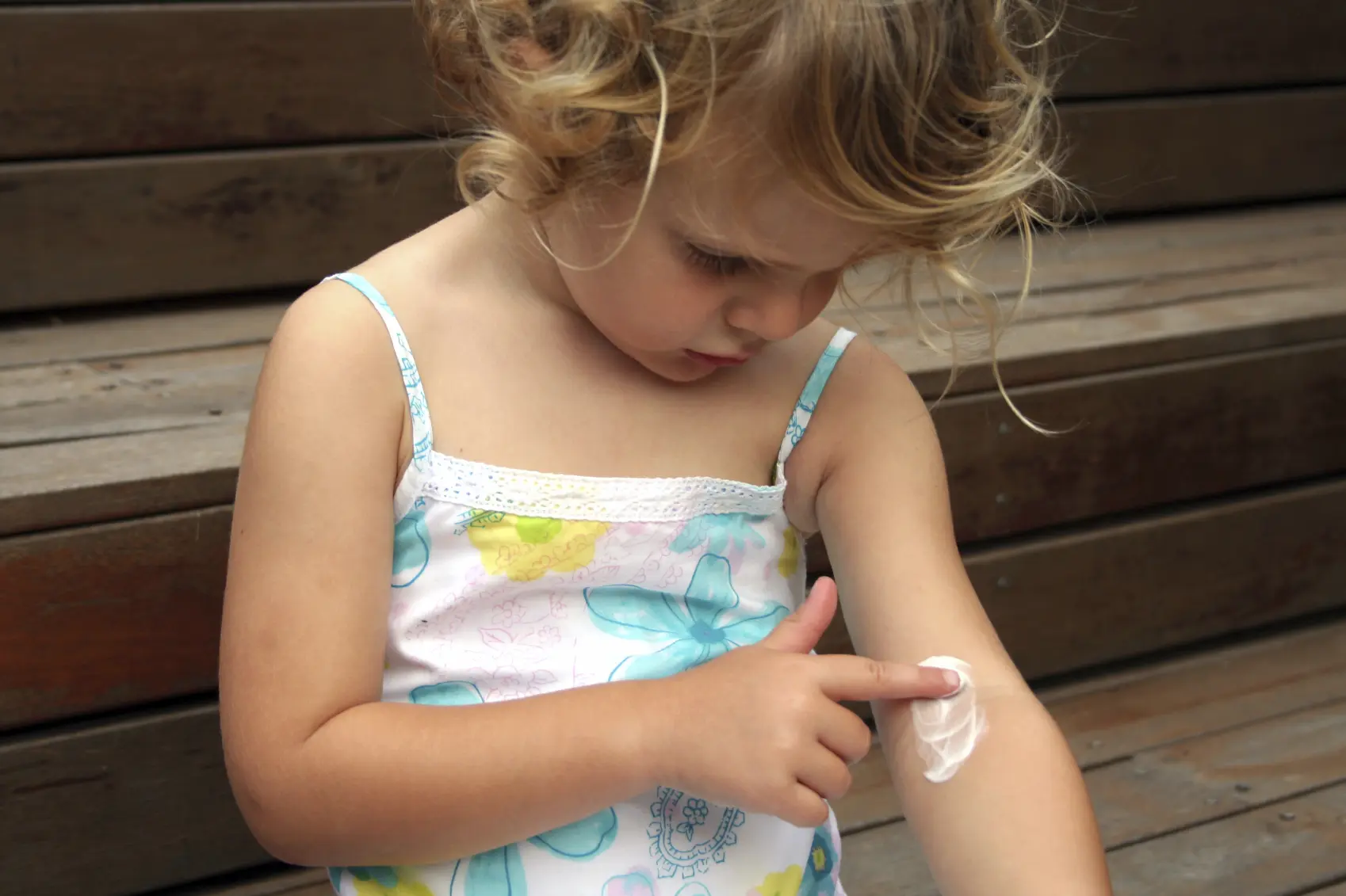 Young girl touching a band aid on her arm
