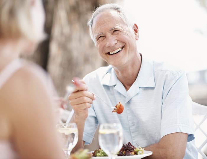 Senior man and woman eating outside