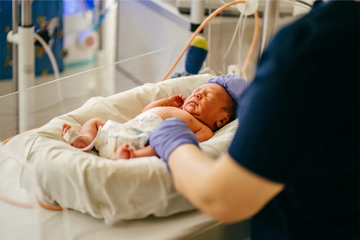 Newborn baby in a hospital setting being examined by a doctor