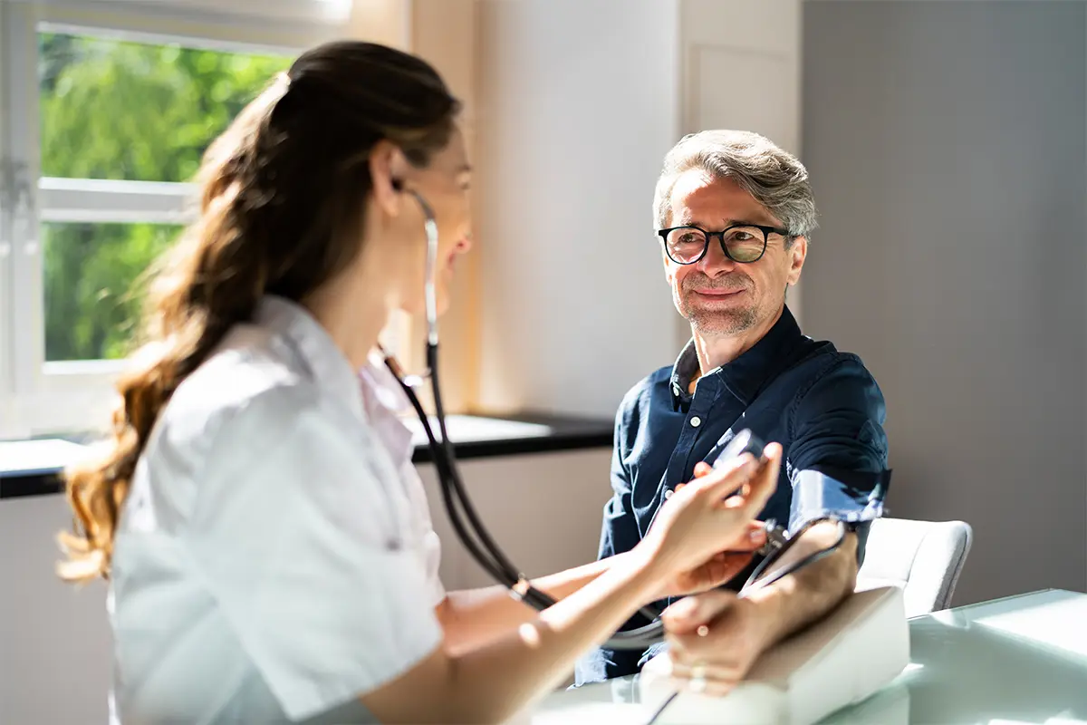 Man in glasses talking to a doctor in the sunlight