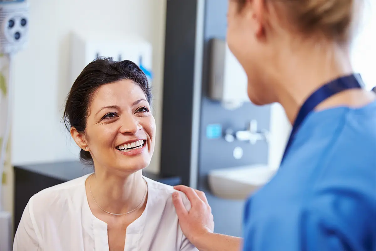 Smiling woman talking to a medical professional 