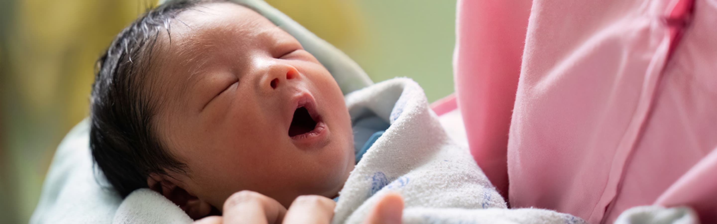 Close up of a small baby yawning