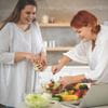 woman serving another woman fruit salad
